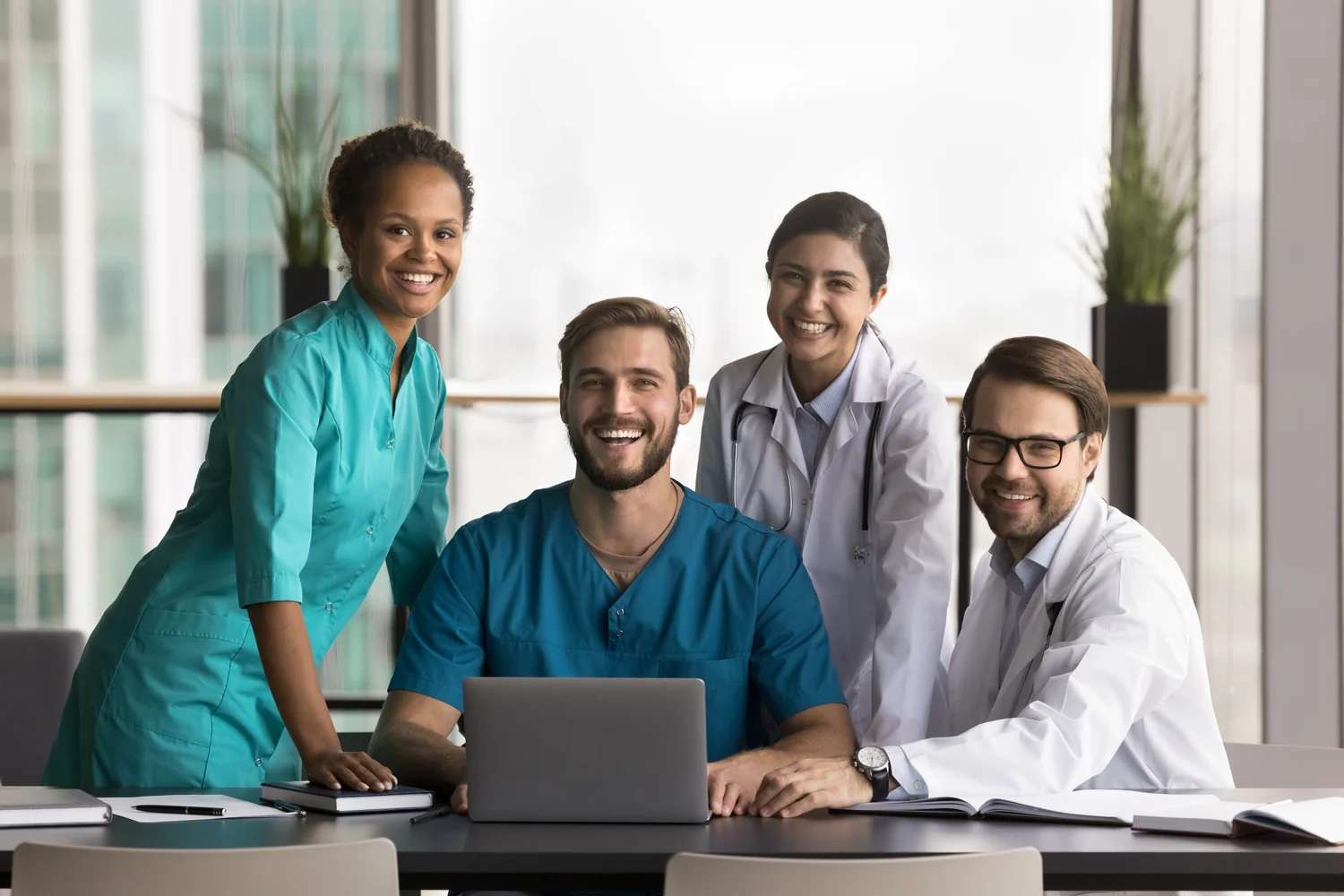 Healthcare professionals collaborating around a laptop